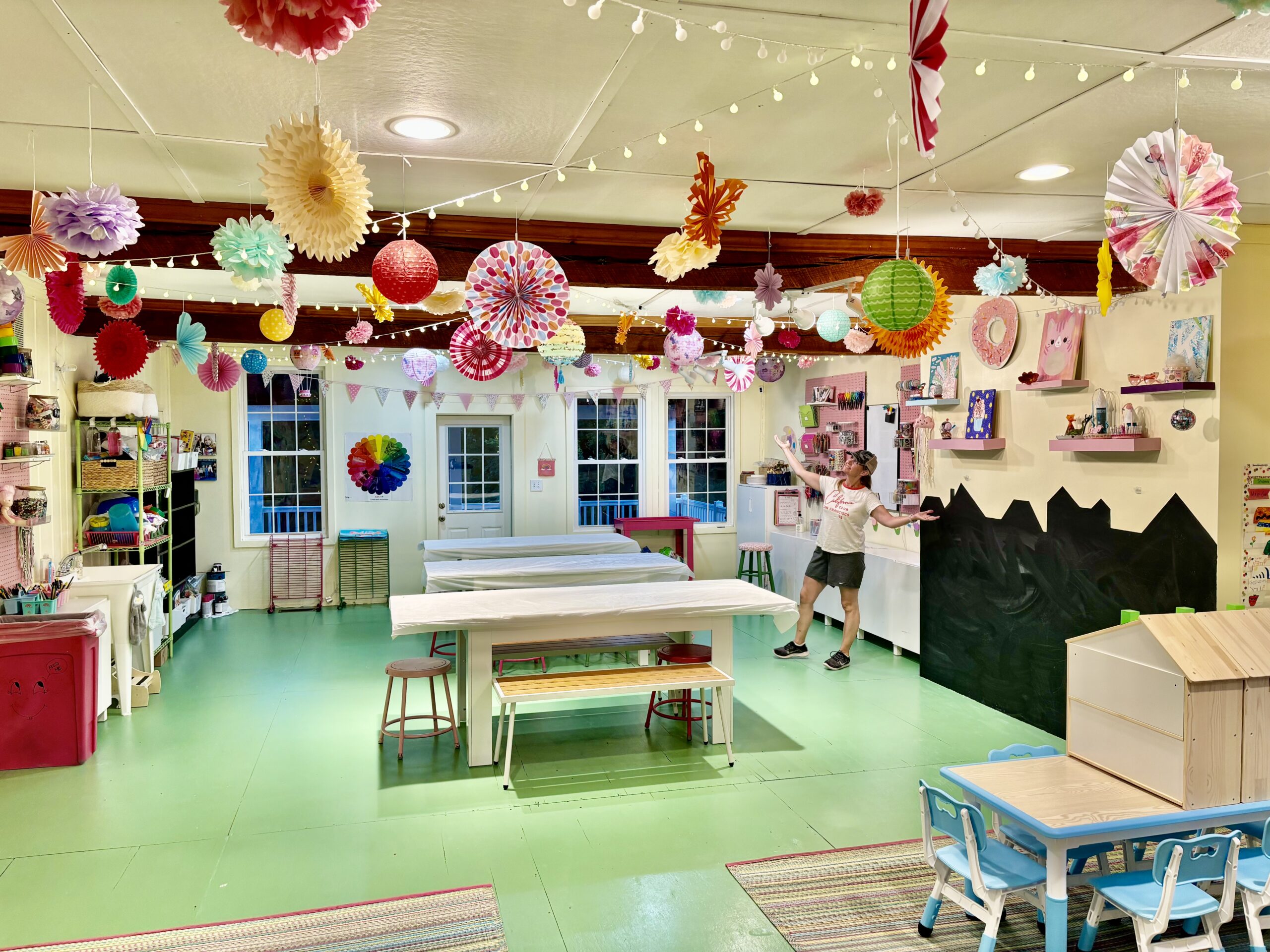 Colorful children’s art studio at Pink Art Pixie in Joppa, Maryland. Inside Pink Art Pixie’s colorful children’s art studio in Joppa, MD, with spacious art tables, whimsical ceiling decorations, organized supplies and a welcoming space for kids’ classes, camps and parties. Bright and colorful children’s art studio at Pink Art Pixie in Joppa, Maryland, featuring craft tables, hanging paper decorations, art supplies and creative displays.