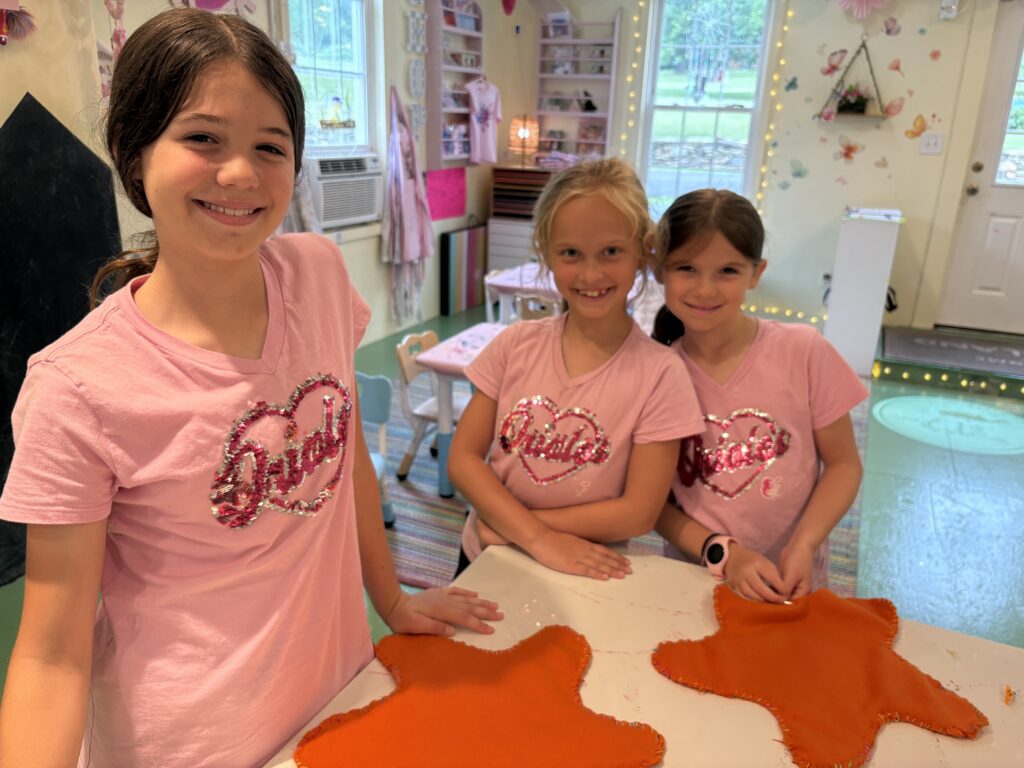 Children displaying hand-sewn starfish projects during Surfin’ USA Art Camp at Pink Art Pixie in Joppa, Maryland