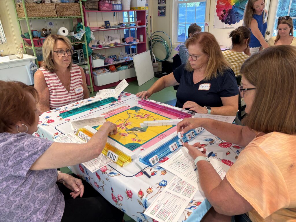 Women learning American Mahjong during a beginner class at Pink Art Pixie in Joppa, Maryland