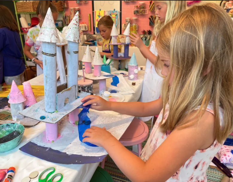 Young artist painting a whimsical castle sculpture during Princess Castles in the Sky Art Camp at Pink Art Pixie in Joppa, Maryland